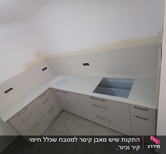 משטח שיש לבן עם כיור מובנה במטבח